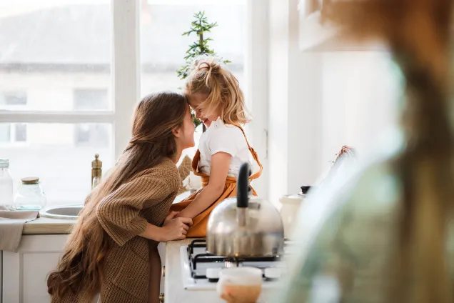 sœurs riant ensemble dans la cuisine