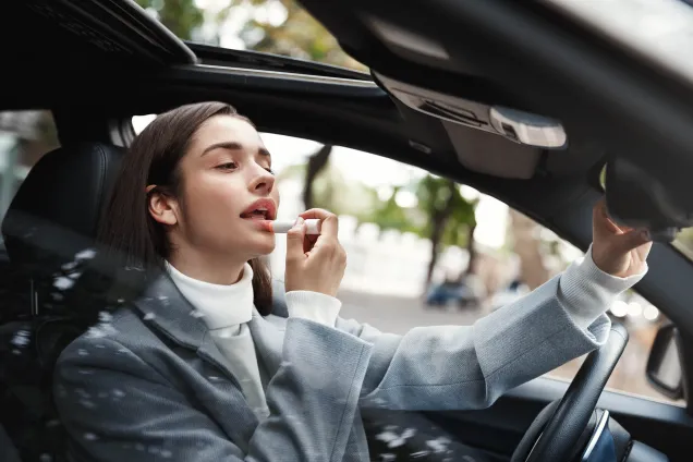 femme conducteur appliquant du rouge à lèvres