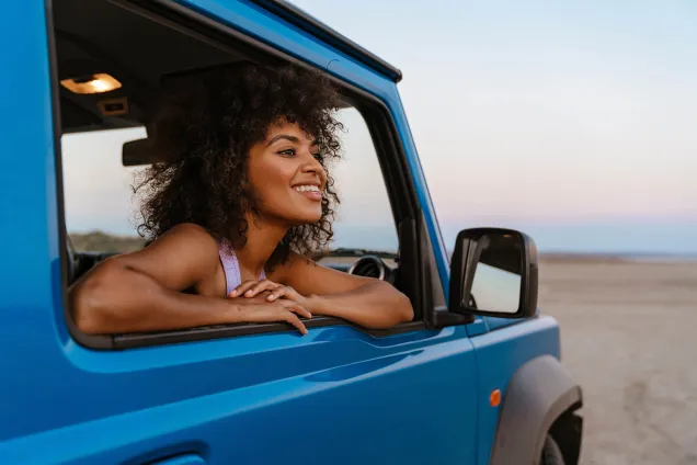 passagère regardant par la fenêtre d'une voiture bleue