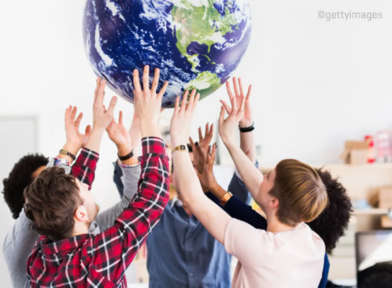 Les gens tiennent un globe terrestre ensemble en tête
